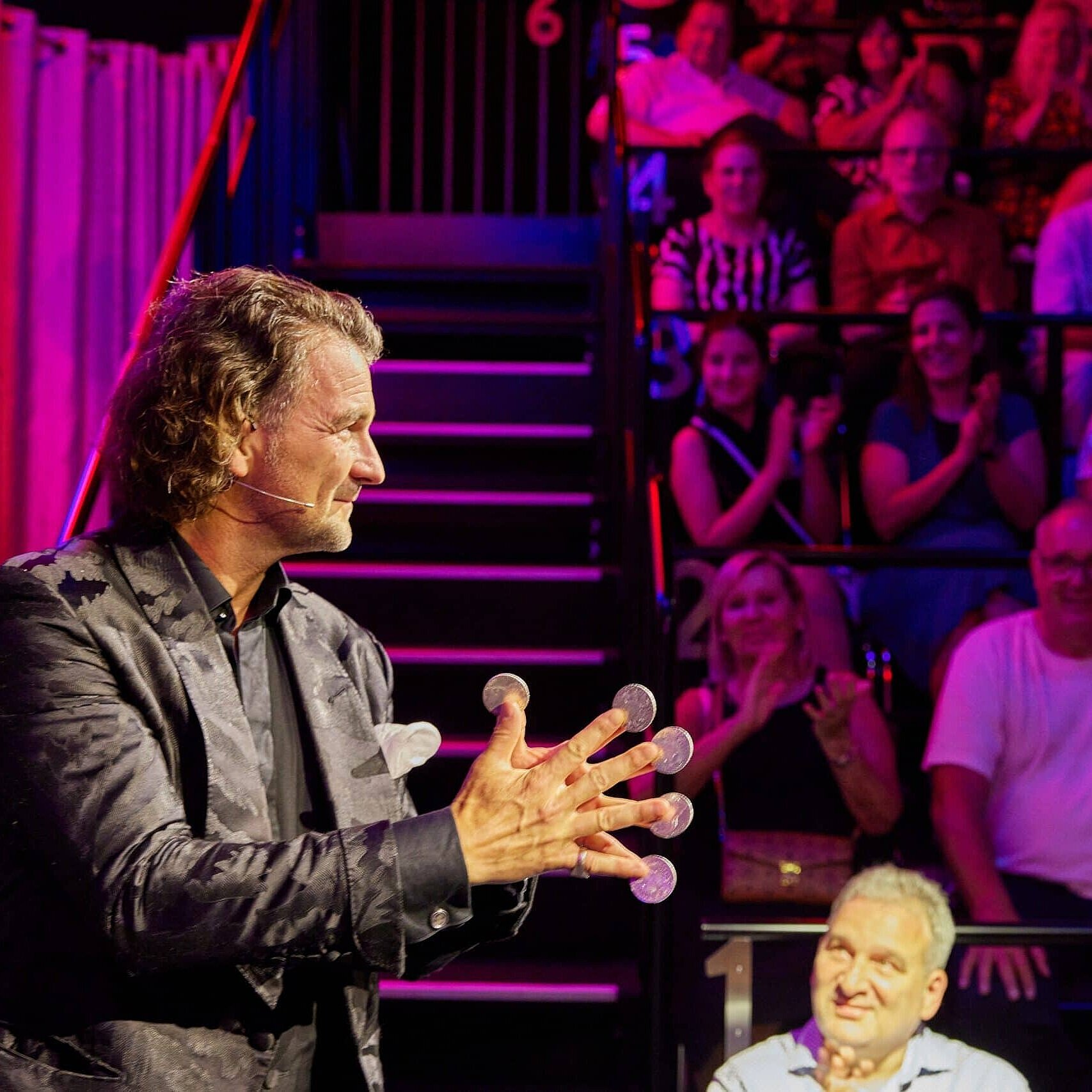 STROTMANNS Magic Lounge Entertainer bei einer Live-Show vor Publikum in stimmungsvoll beleuchtetem Veranstaltungsraum.