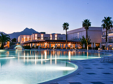 Schwimmbad Poolbeleuchtung am Abend im Maritim Resort Calabria mit Palmen und Gebirgskulisse