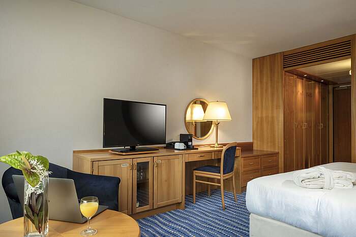 Superior Zimmer Schreibtisch mit Fernseher und Lampe in einem Superior-Zimmer mit Holzeinrichtung und blauen Akzenten.