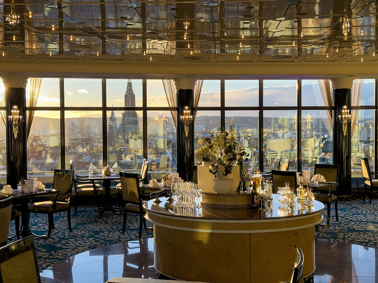 Das Ulmer Restaurant Elegantes Restaurant im Maritim Hotel Ulm mit großen Panoramafenstern und Blick über die Stadt bei Sonnenuntergang