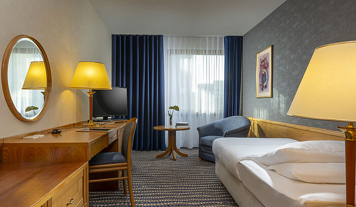 Classic Einzelzimmer Freundlich eingerichtetes Zimmer mit Schreibtisch, Bett und Sessel im Maritim Hotel Magdeburg