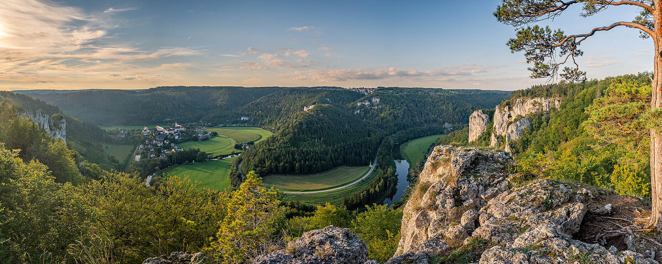 © mindscapephotos - AdobeStock.com Panorama über das Donautal mit Fluss, grünen Wiesen und steilen Felsen