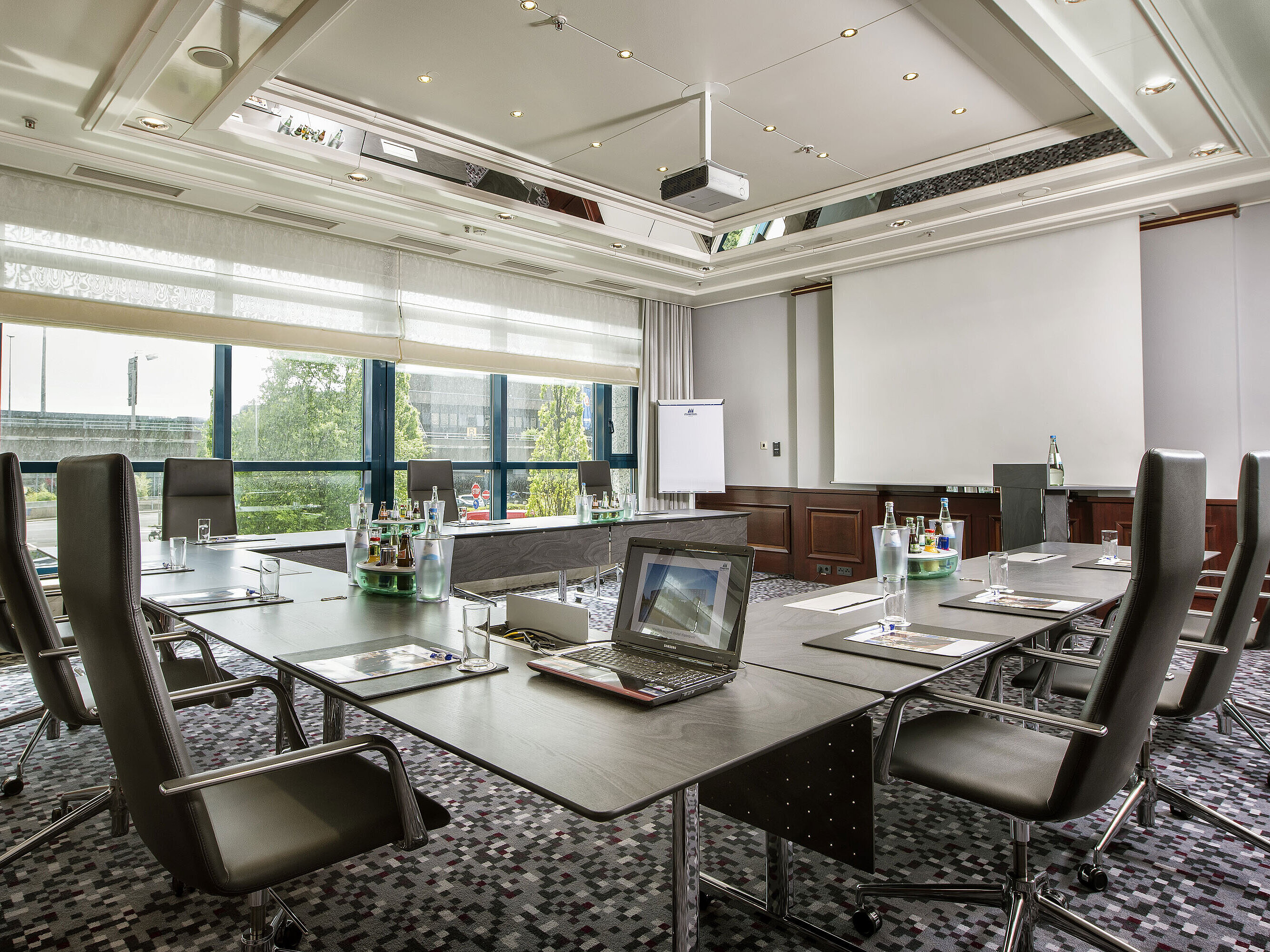 Salon Ernst August Heller Tagungsraum mit großem Konferenztisch, Ledersesseln und moderner Technik im Maritim Hotel Hannover.
