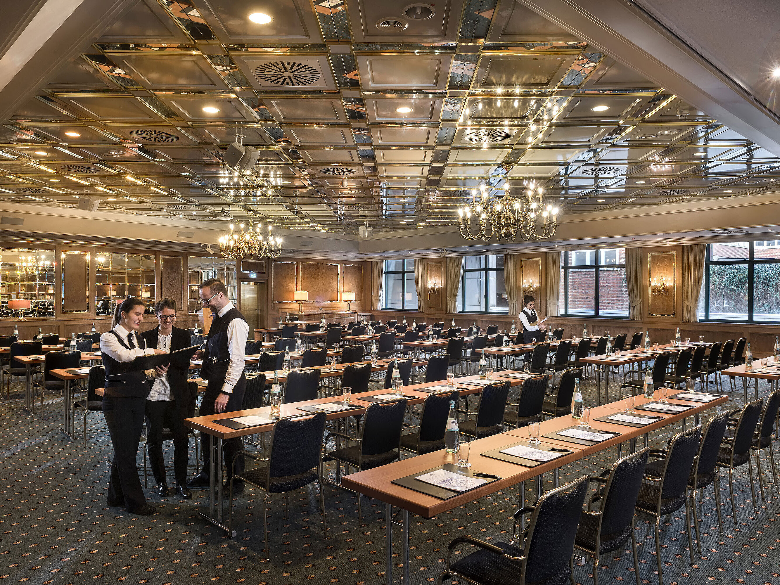 Saal Maritim Zwei Mitarbeitende bereiten einen Konferenzraum mit Reihenbestuhlung im Maritim Hotel Stuttgart vor
