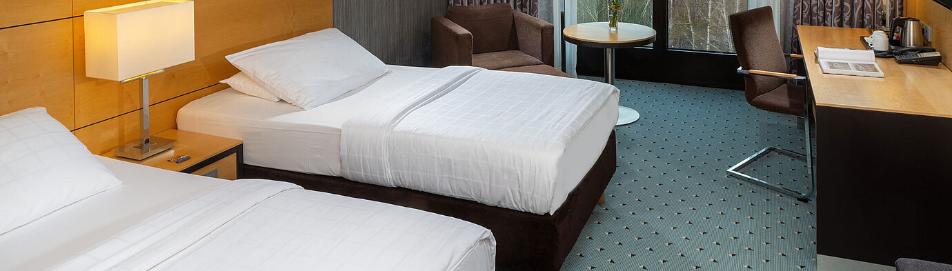 Classic Twin Zimmer Classic Zimmer im Maritim Hotel Düsseldorf mit zwei Einzelbetten, Schreibtisch,Sessel und Fenster mit Blick auf den Flughafen