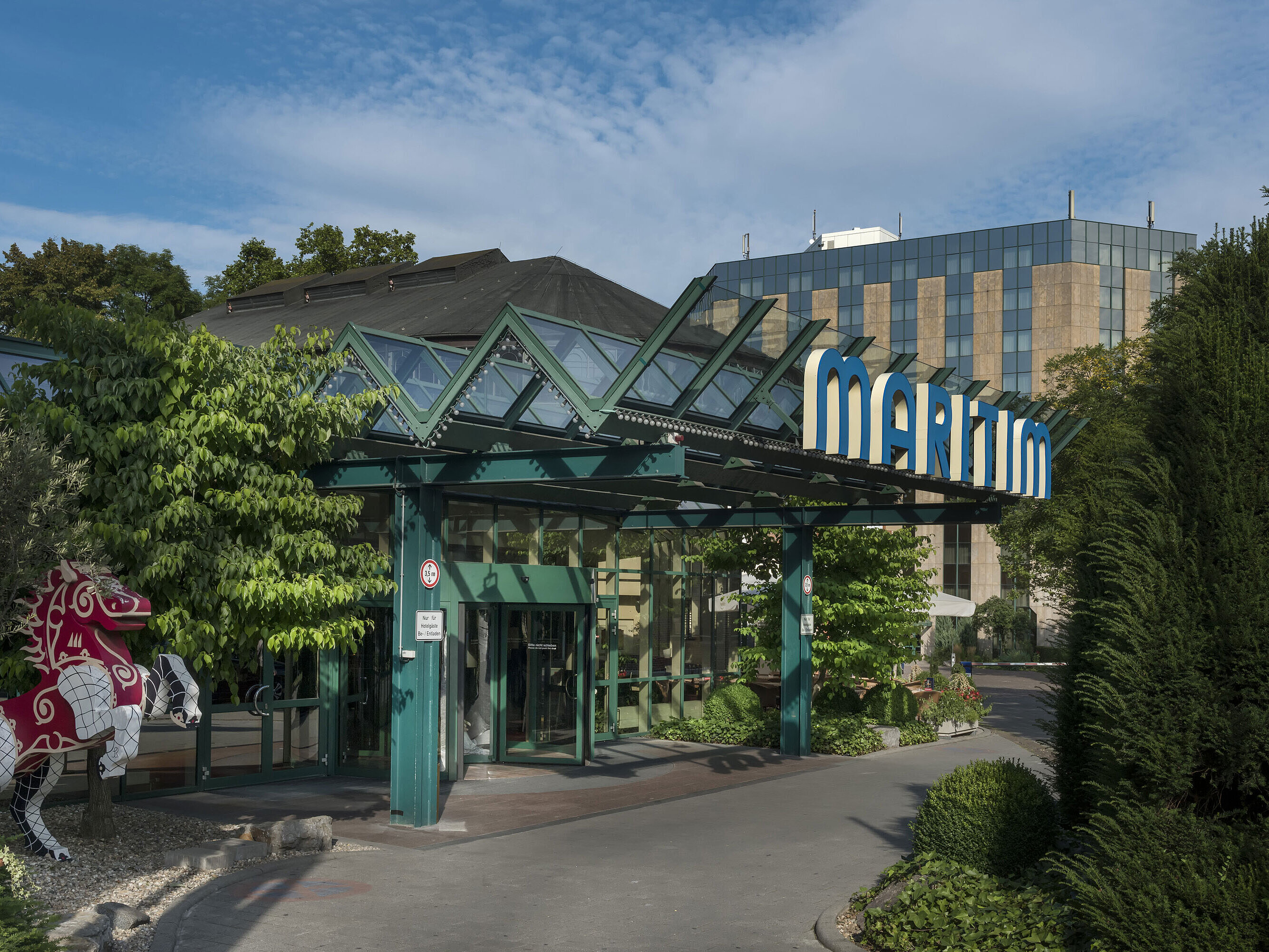 Eingang des Hotels Haupteingang des Maritim Hotel Stuttgart mit Glasdach, grünem Eingangsbereich und Maritim-Schriftzug