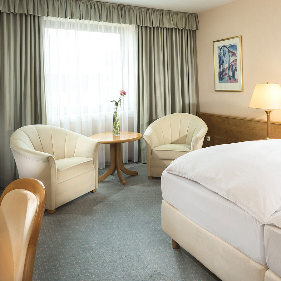 Superior Zimmer  Helles Hotelzimmer mit zwei Betten, Sitzgruppe und großem Fenster im Maritim Hotel Magdeburg