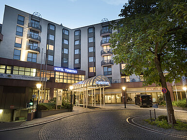 Außenansicht bei Nacht Stimmungsvoller Hoteleingang des Maritim Hotel Bad Homburg in der Abenddämmerung mit Beleuchtung.