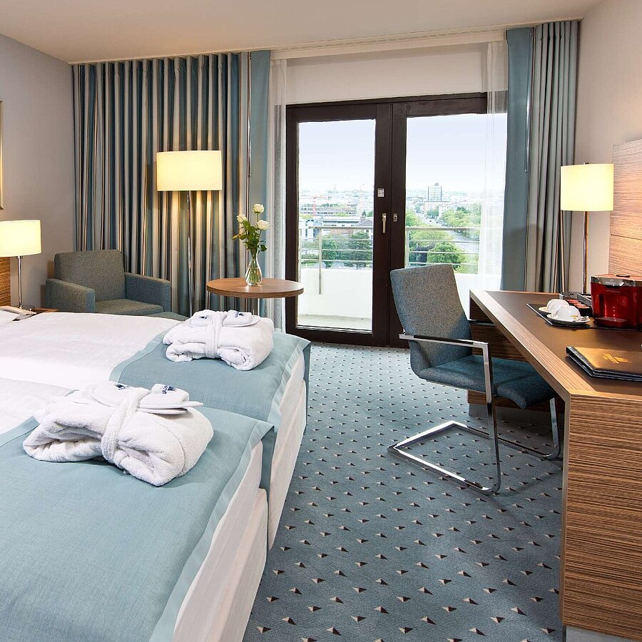 Superior Zimmer  Superior Zimmer im Maritim Hotel Darmstadt mit stilvollem Design, Schreibtisch, Sitzecke und Doppelbett mit Bademänteln.