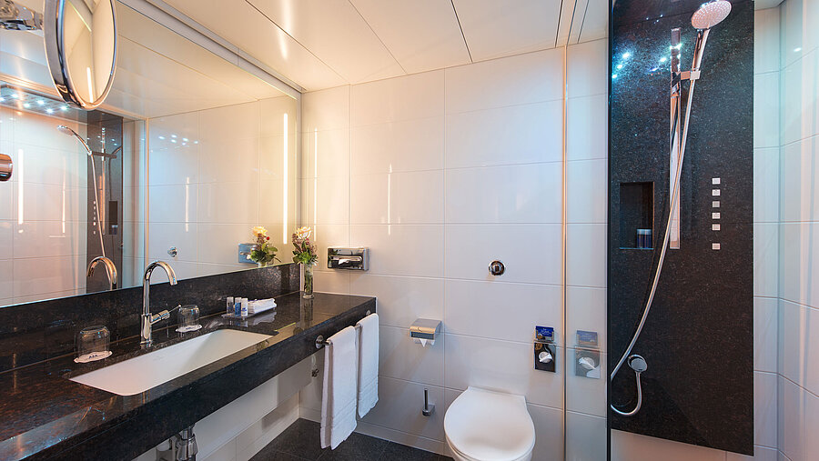 Badezimmer Geräumiges Bad mit Dusche, WC, Spiegel und Granitwaschtisch im Maritim Hotel Stuttgart