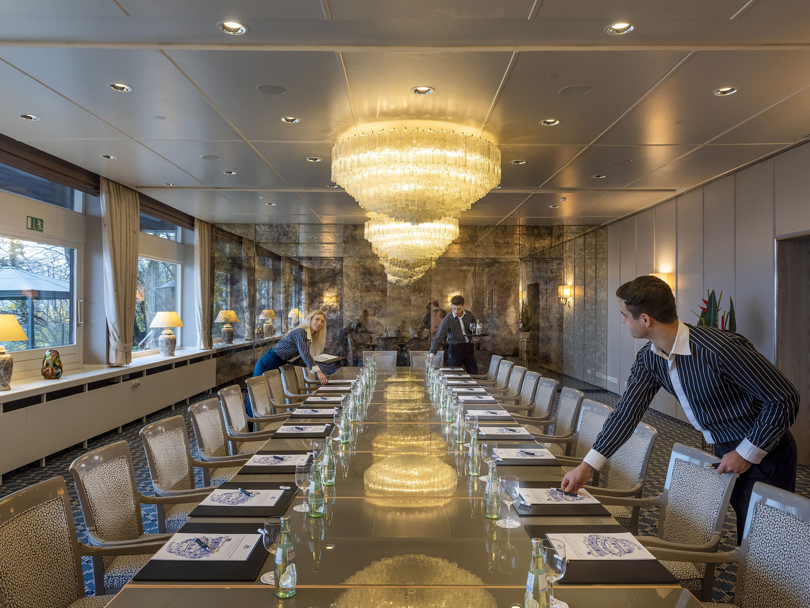 Salon Oslo Salon Oslo im Maritim Hotel Kiel, eleganter Konferenzraum mit Kronleuchtern und langer Tischreihe, Personal richtet den Raum ein.