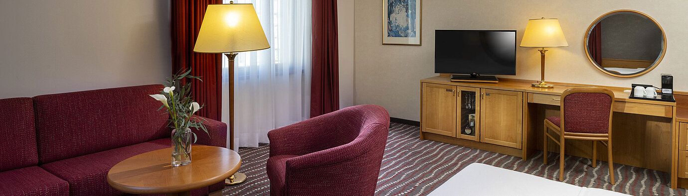 Studio Komfortables Studiozimmer im Maritim Hotel Magdeburg mit Sitzecke, Schreibtisch und modernem TV.