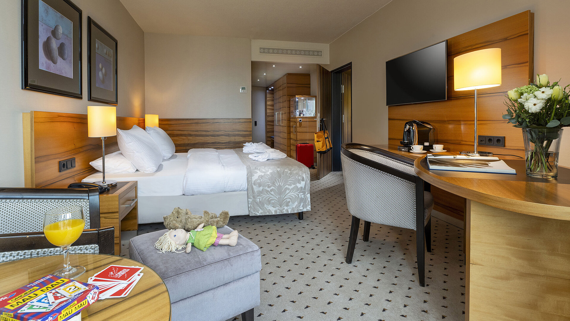 Superior Familienzimmer Komfortzimmer im Maritim Hotel Bad Homburg mit Doppelbett, Spielzeug, Kuscheltier und modernem Holzdekor.