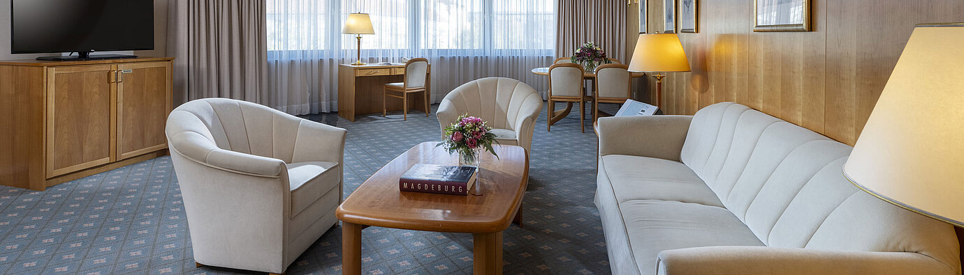 Suite Großzügiges Wohnzimmer einer Suite im Maritim Hotel Magdeburg mit eleganter Einrichtung, Sitzecke und Arbeitsplatz.