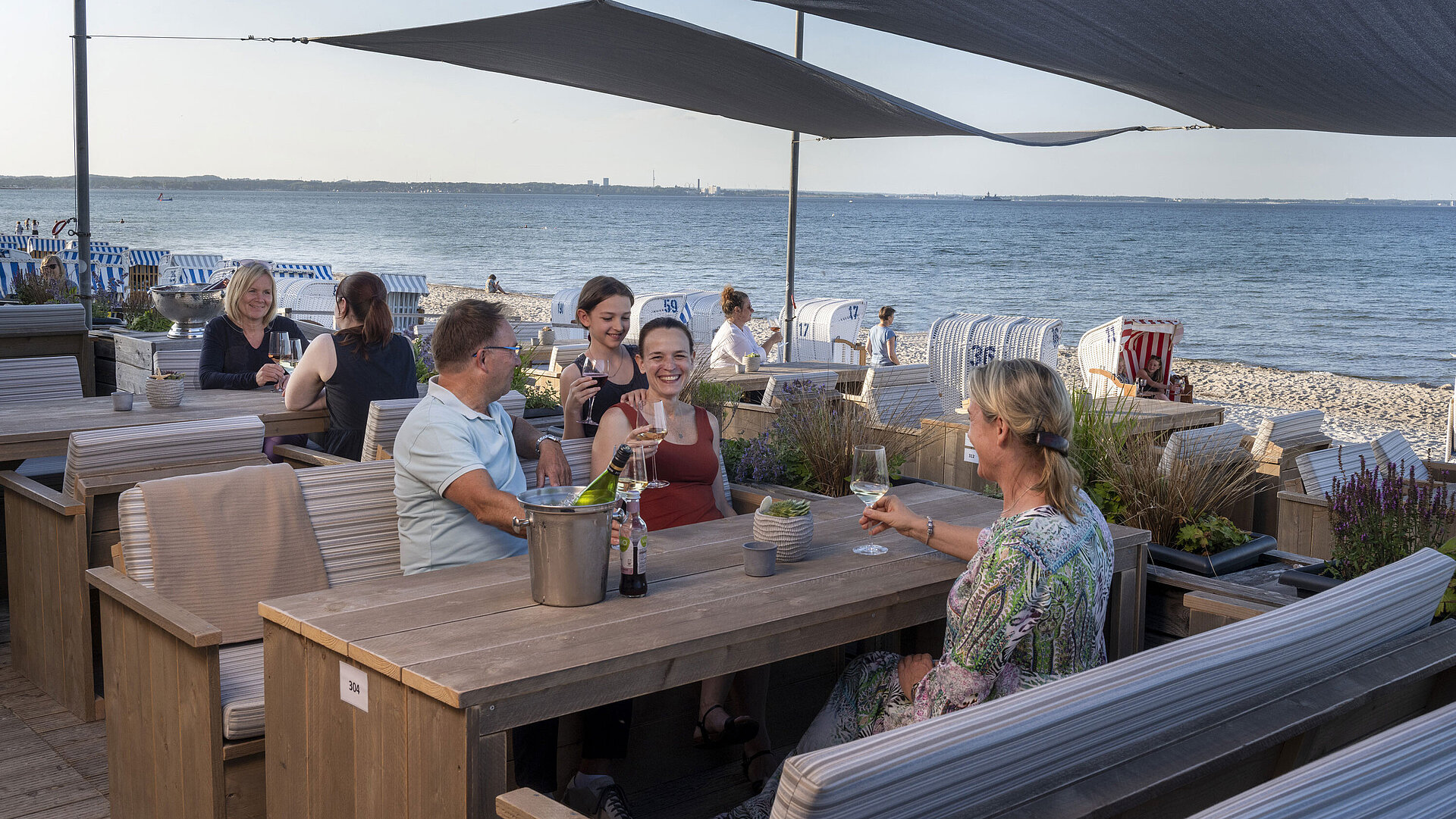 Beach Lounge Gruppe von Gästen in der Strandbar des Maritim Seehotel Timmendorfer Strand, genießt Drinks mit Meerblick und Strandkörben.