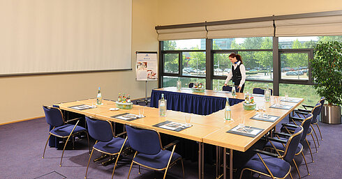 Tagungsraum Tagungsraum im Maritim Hotel Dresden mit U-förmiger Tischanordnung, Präsentationsleinwand und Vorbereitungen für ein Meeting.