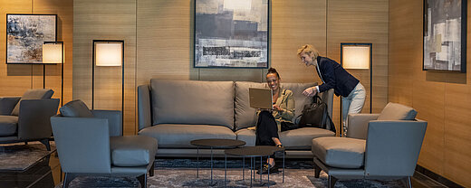 Lounge Zwei Frauen arbeiten in der eleganten Lounge des Maritim Hotel Ingolstadt mit Laptop und moderner Einrichtung.