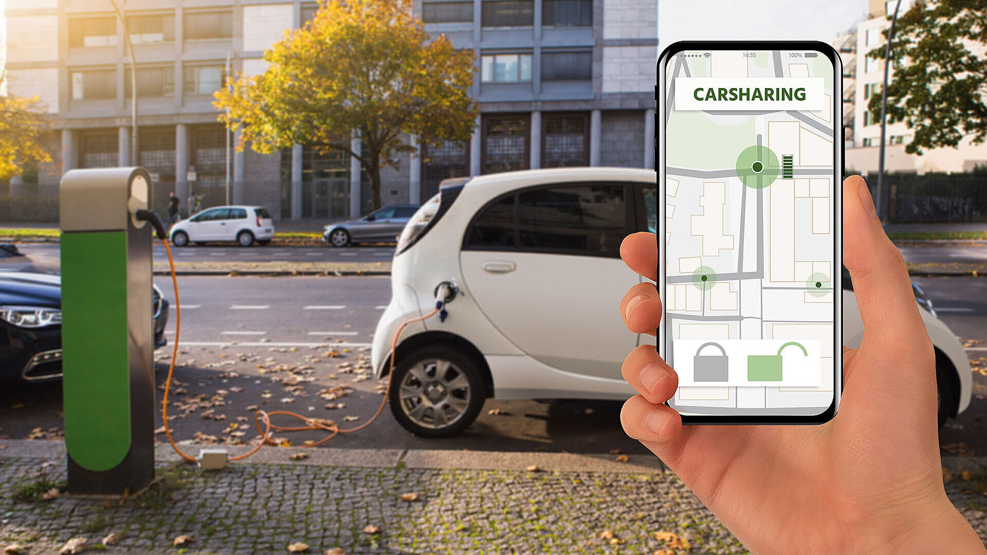 © scharfsinn86-AdobeStock.com Elektroauto lädt an Station, gesteuert über Carsharing-App auf Smartphone
