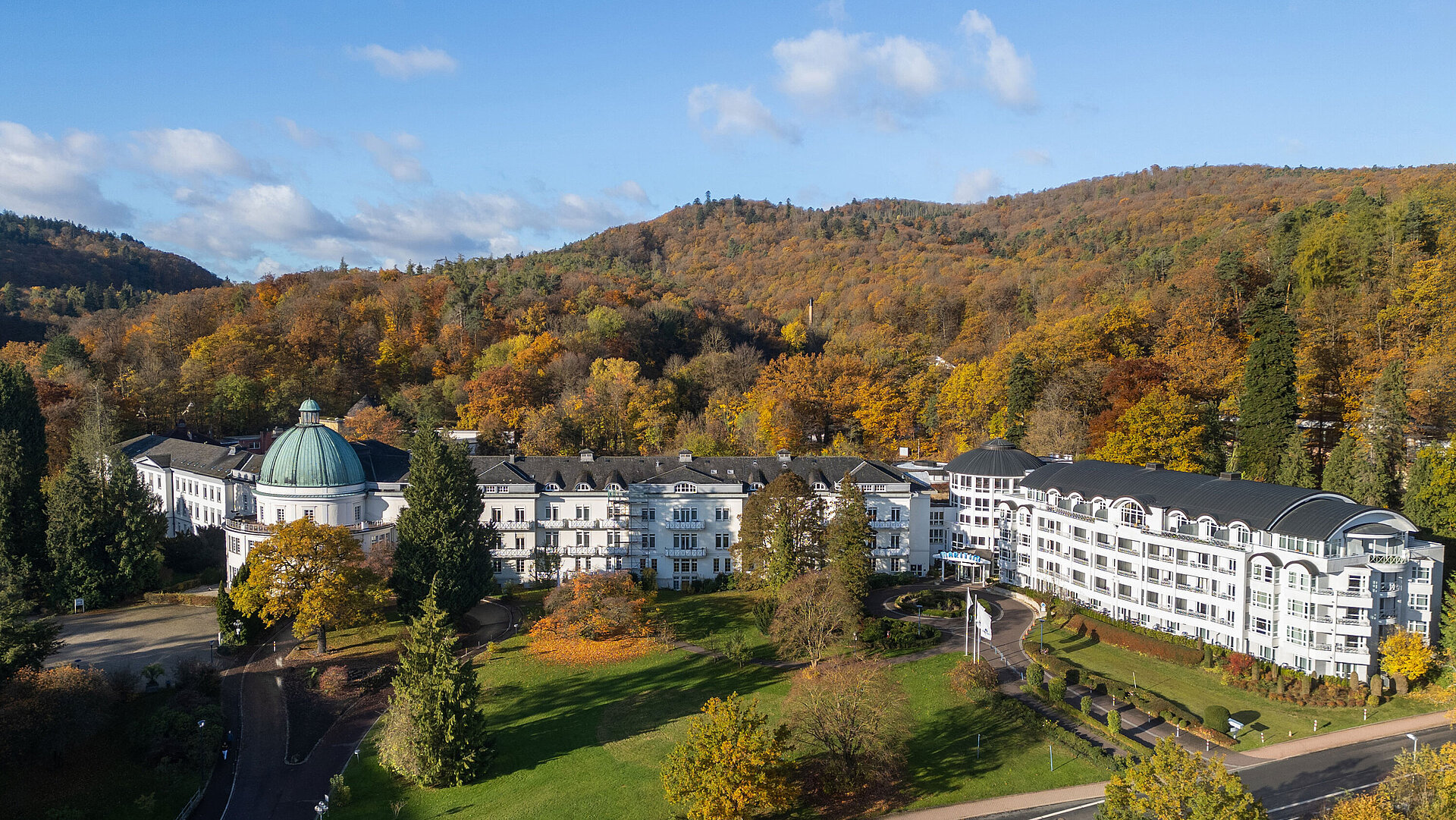 Aussenansicht Außenansicht des Maritim Hotel Bad Wildungen, umgeben von Park, Bäumen und herbstlichem Waldpanorama.