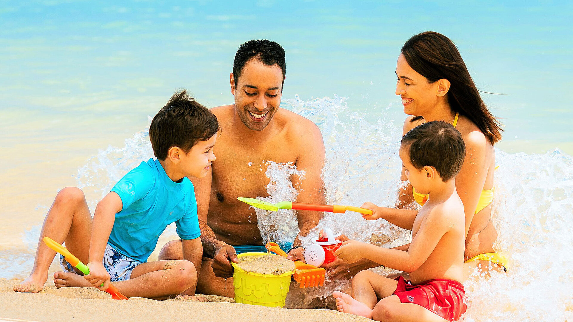 Strand Familie spielt mit Kindern am Strand und genießt den Badeurlaub