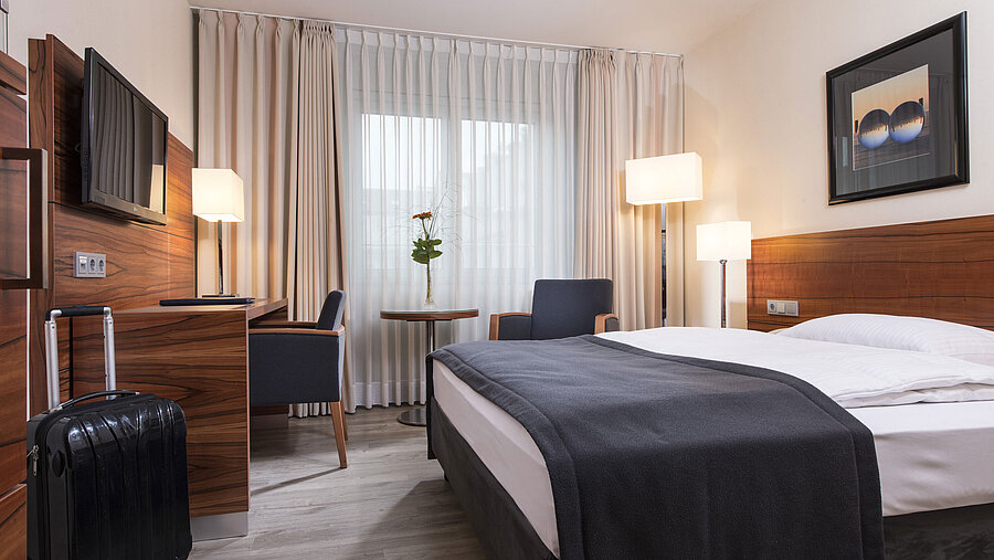 Allergikerzimmer Gemütliches Zimmer mit Doppelbett, Schreibtisch und Koffer im Maritim Hotel München