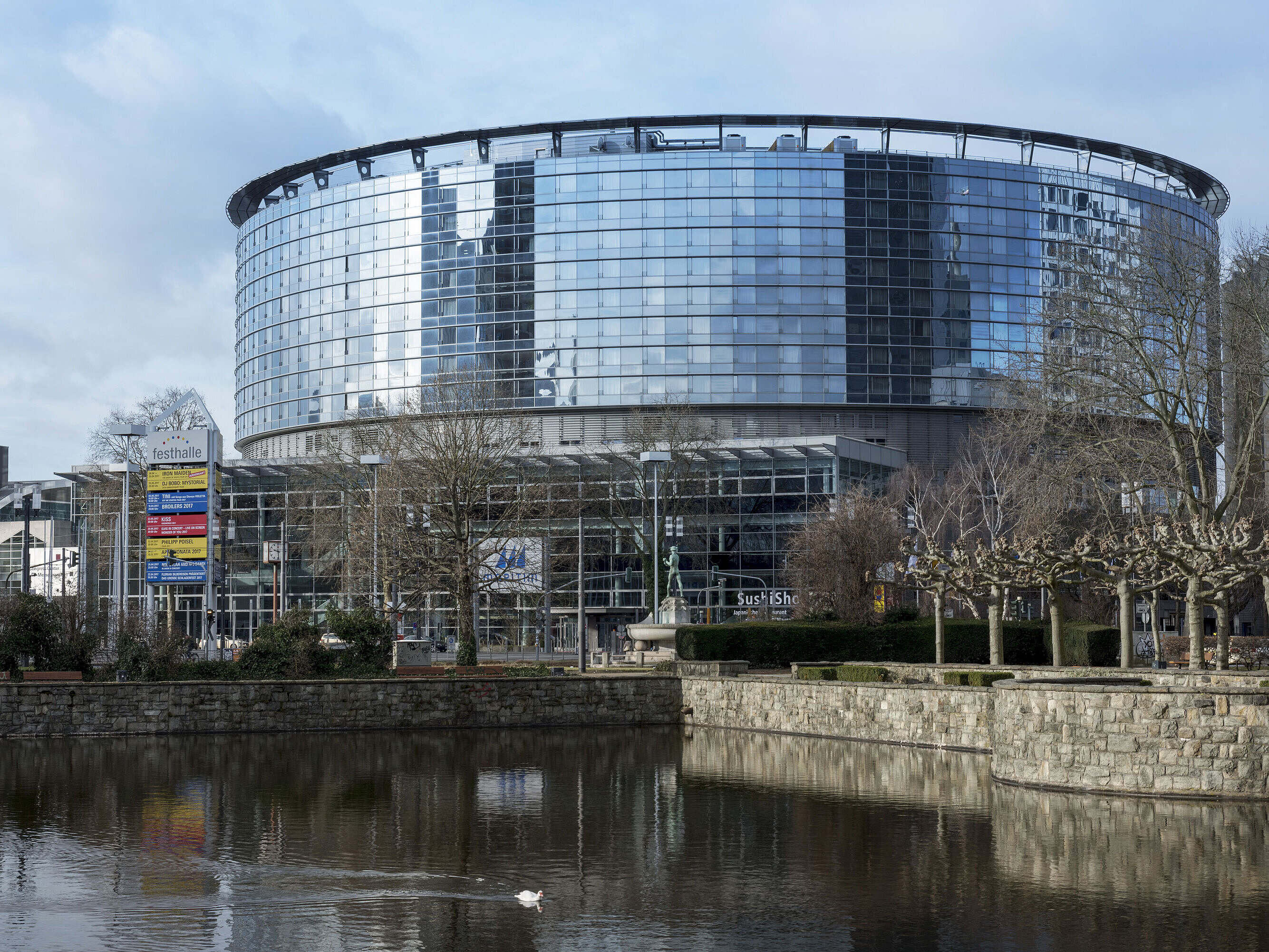 Außenansicht Außenansicht des Maritim Hotel Frankfurt mit moderner Glasfassade und angrenzendem Teich bei Tageslicht.