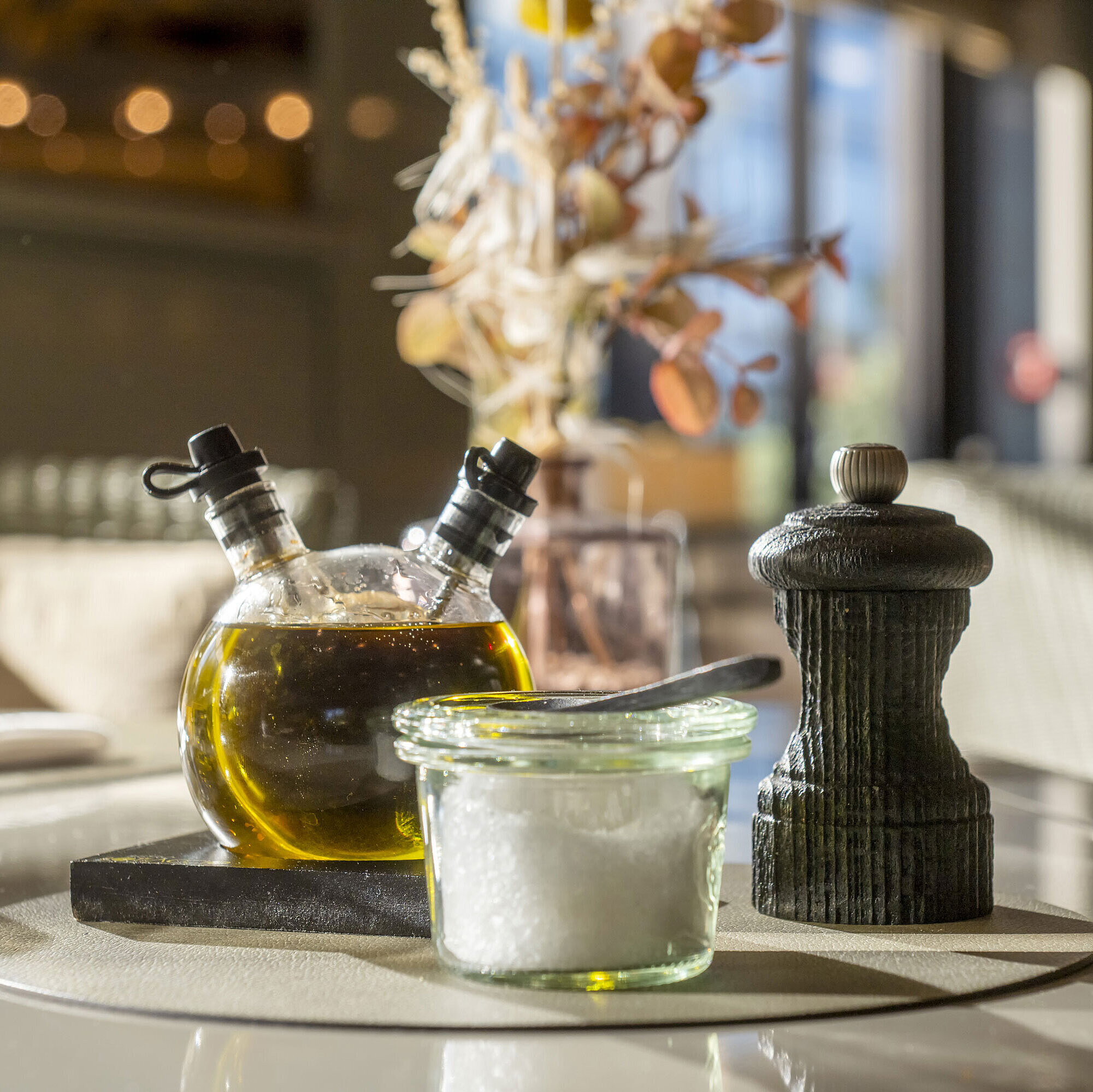 Restaurantdetail Detailaufnahme eines gedeckten Tisches im Maritim Hotel Düsseldorf mit Olivenöl, Salz und Pfefferstreuer.