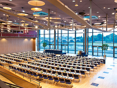 Saal 1&2 Großer Konferenzsaal im Maritim Hotel Dresden mit Reihen blauer Stühle und Blick auf die Elbe.