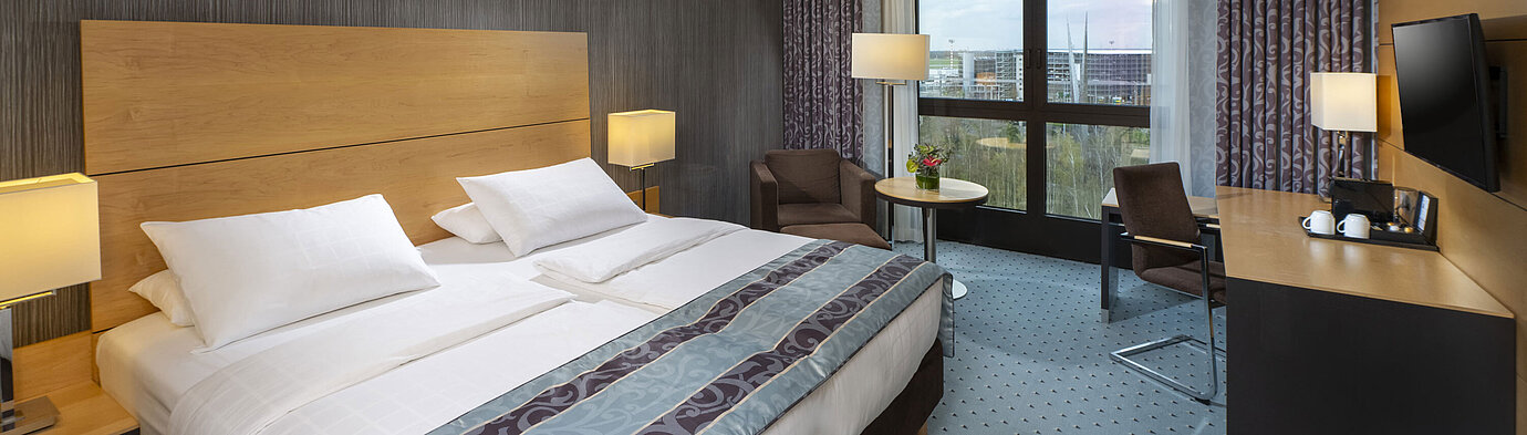 Superior Zimmer Modernes Superior-Zimmer im Maritim Hotel Düsseldorf mit großem Bett, Schreibtisch und Blick auf die Stadt.