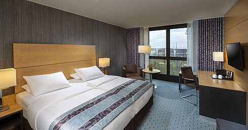 Superior Zimmer Modernes Superior-Zimmer im Maritim Hotel Düsseldorf mit großem Bett, Schreibtisch und Blick auf die Stadt.