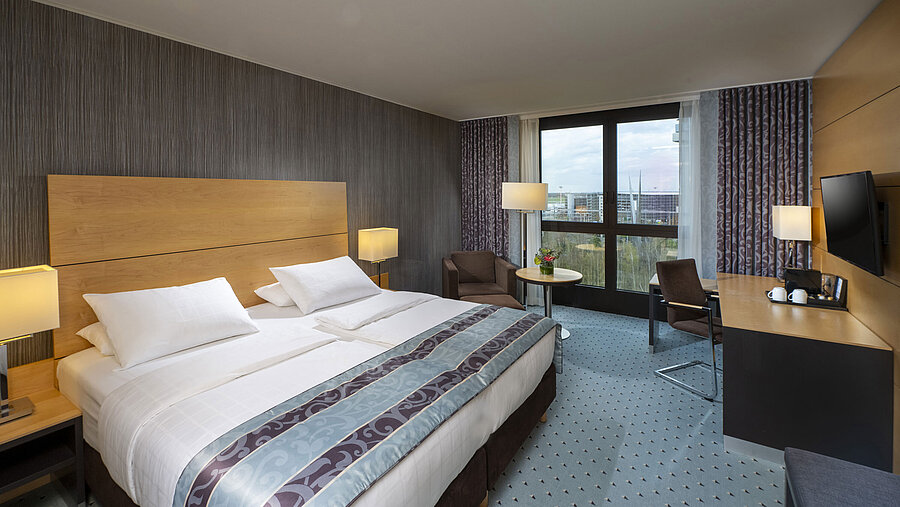Superior Zimmer Modernes Superior-Zimmer im Maritim Hotel Düsseldorf mit großem Bett, Schreibtisch und Blick auf die Stadt.