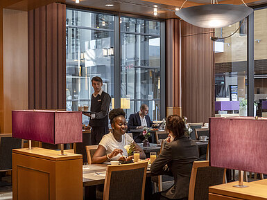 Restaurant Classico Gäste genießen ihr Frühstück im Restaurant Classico des Maritim Hotel Düsseldorf, während ein Mitarbeiter Getränke serviert.
