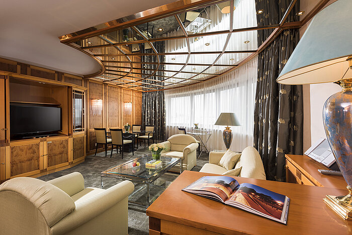 Luxus Suite Blick in die luxuriöse Suite mit gemütlicher Sitzecke, TV und dekorativem Decken-Design im Maritim Hotel Magdeburg