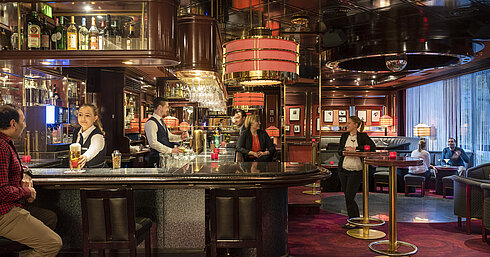 Binnen Bremer Bar Gäste genießen Drinks und entspannte Atmosphäre in der stilvollen Bar des Maritim Bremen, bedient von freundlichem Personal.