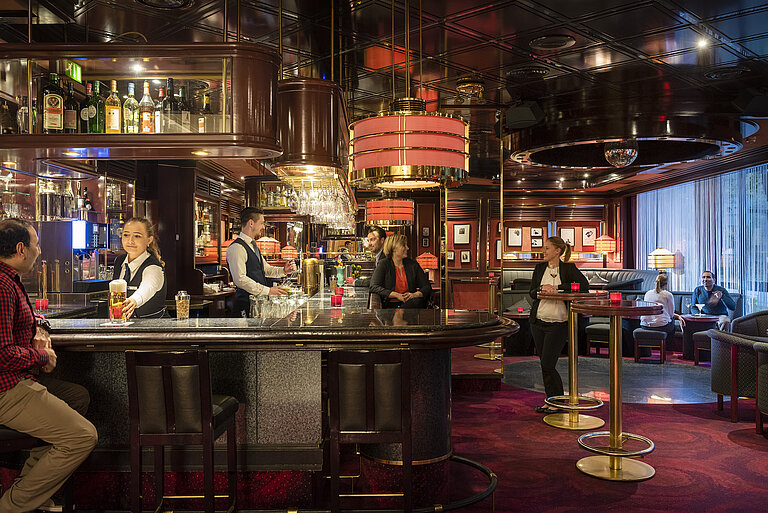 Binnen Bremer Bar Gäste genießen Drinks und entspannte Atmosphäre in der stilvollen Bar des Maritim Bremen, bedient von freundlichem Personal.