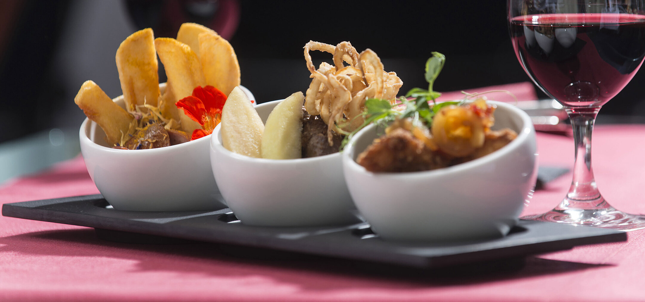 Tapas im berlin tapas Nahaufnahme von Tapas im Maritim proArte Hotel Berlin, mit verschiedenen Köstlichkeiten und einem Glas Rotwein im Hintergrund