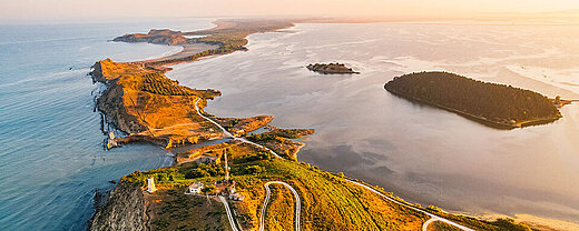 © Zedspider- AdobeStock.com Luftaufnahme einer sonnigen Küstenlandschaft mit Inseln und türkisblauem Meer