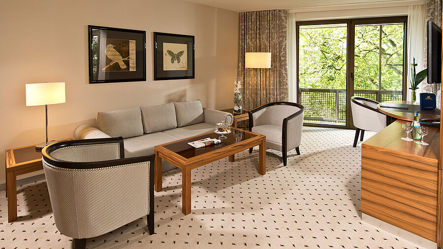 Studio Gemütlicher Wohnbereich der Suite im Maritim Hotel Bad Homburg mit eleganter Sitzecke und Balkon.