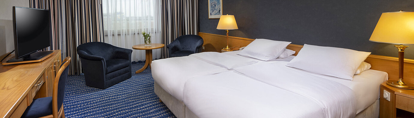 Comfort Zimmer Comfort-Doppelzimmer mit Sitzbereich, Schreibtisch und modernen Kunstwerken an der Wand