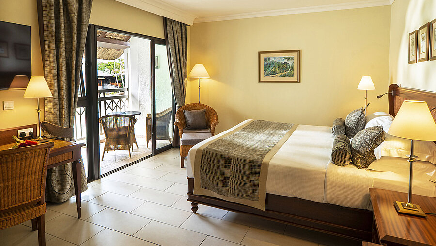 Classic Zimmer Helles Hotelzimmer mit Balkon, gemütlicher Leseecke, Tisch und modernem Mobiliar