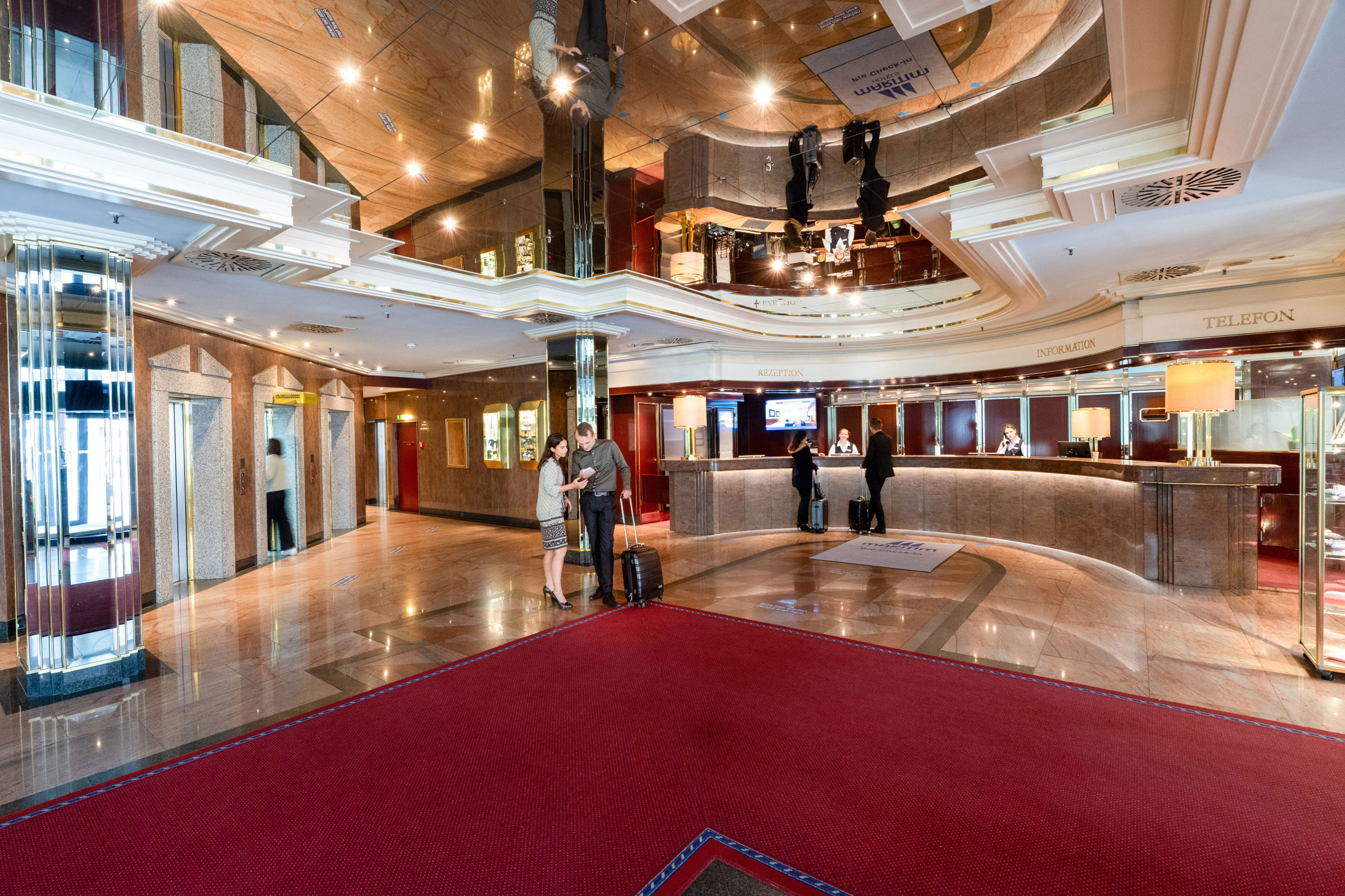 Rezeption Elegante Hotellobby mit Rezeption und Gästen beim Check-in im Maritim Hotel München.