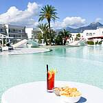 Snacks und ein Cocktail am Lagunenpool des Maritim Resort Calabria. Perfekte Auszeit mit Blick auf die Berge.