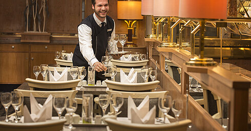 Restaurant "Rôtisserie" Servicekraft mit Tablett voller Gläser im Restaurant des Maritim Hotel Stuttgart, freundlich und einladend