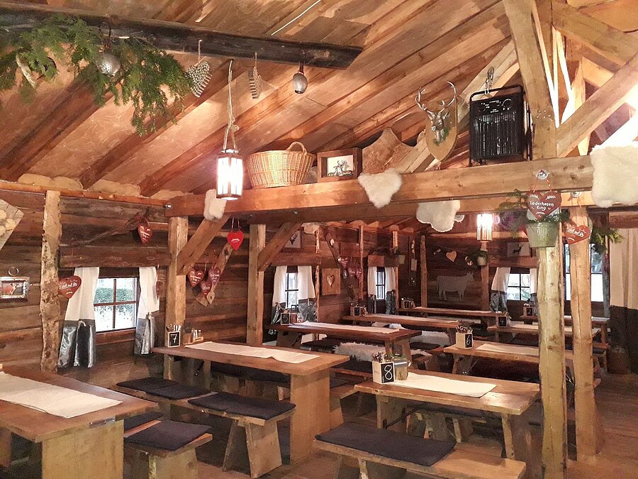 Maritim Alm (innen) Gemütlicher Gastraum mit Holztischen und Almhütten-Deko in der Maritim Alm beim Maritim Hotel Stuttgart