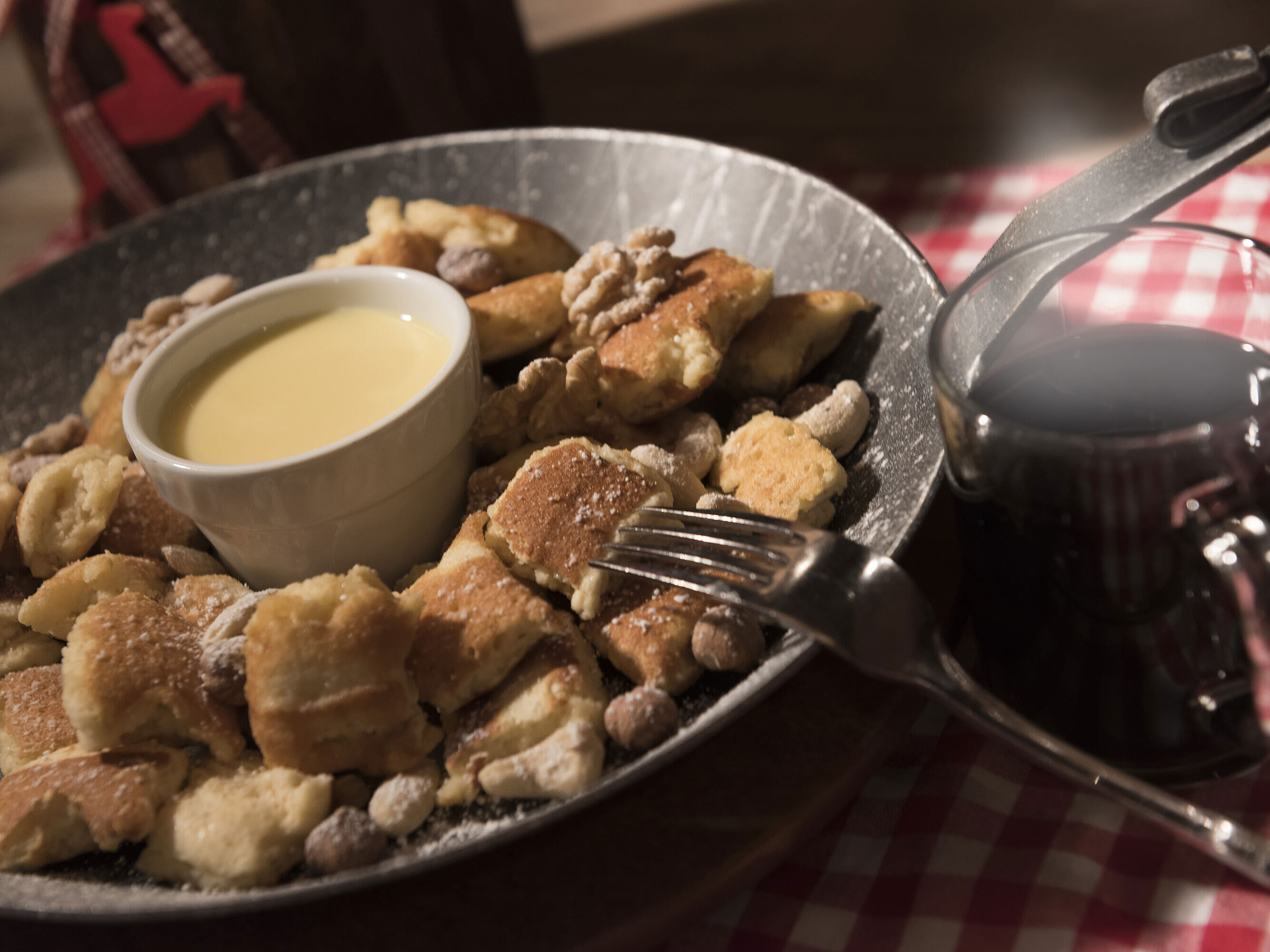 Kaiserschmarrn Frischer Kaiserschmarrn mit Nüssen, Puderzucker und Vanillesauce, serviert mit Glühwein in der Maritim Alm