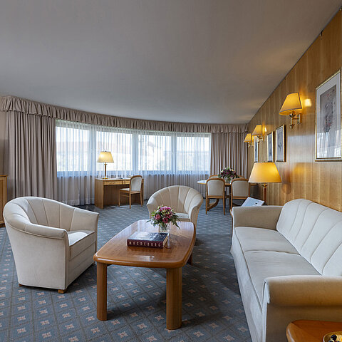 Großzügiges Wohnzimmer einer Suite im Maritim Hotel Magdeburg mit eleganter Einrichtung, Sitzecke und Arbeitsplatz.