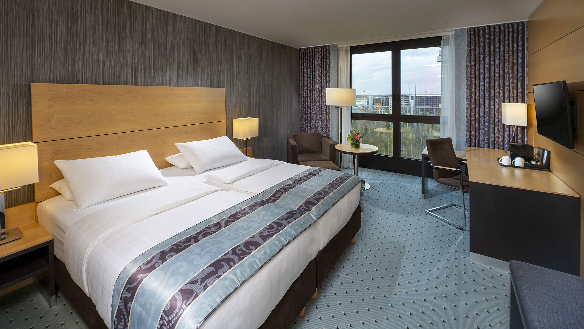 Superior Zimmer Modernes Superior-Zimmer im Maritim Hotel Düsseldorf mit großem Bett, Schreibtisch und Blick auf die Stadt.