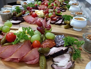Vorspeisenbrett Maritim Alm Herzhaft belegte Brotzeitplatte mit Wurst, Käse, Trauben und Dips in der Maritim Alm Stuttgart